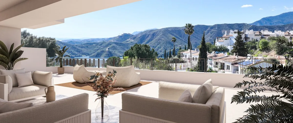 Render of a covered lounge terrace with white sofas, a round coffee table, planting and mountain views.