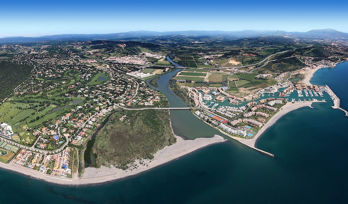 Aerial panoramic view of Sotogrande, Costa del Sol, showing the marina, Guadiaro river estuary, Mediterranean coastline, golf courses, and surrounding residential and rural landscape, shown as local context near VILLAGE VERDE