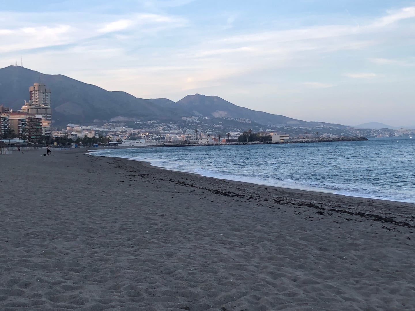 Fuengirola beach and Mediterranean shoreline with coastal town buildings and mountain backdrop at dusk, shown as local context near SANTA AMALIA