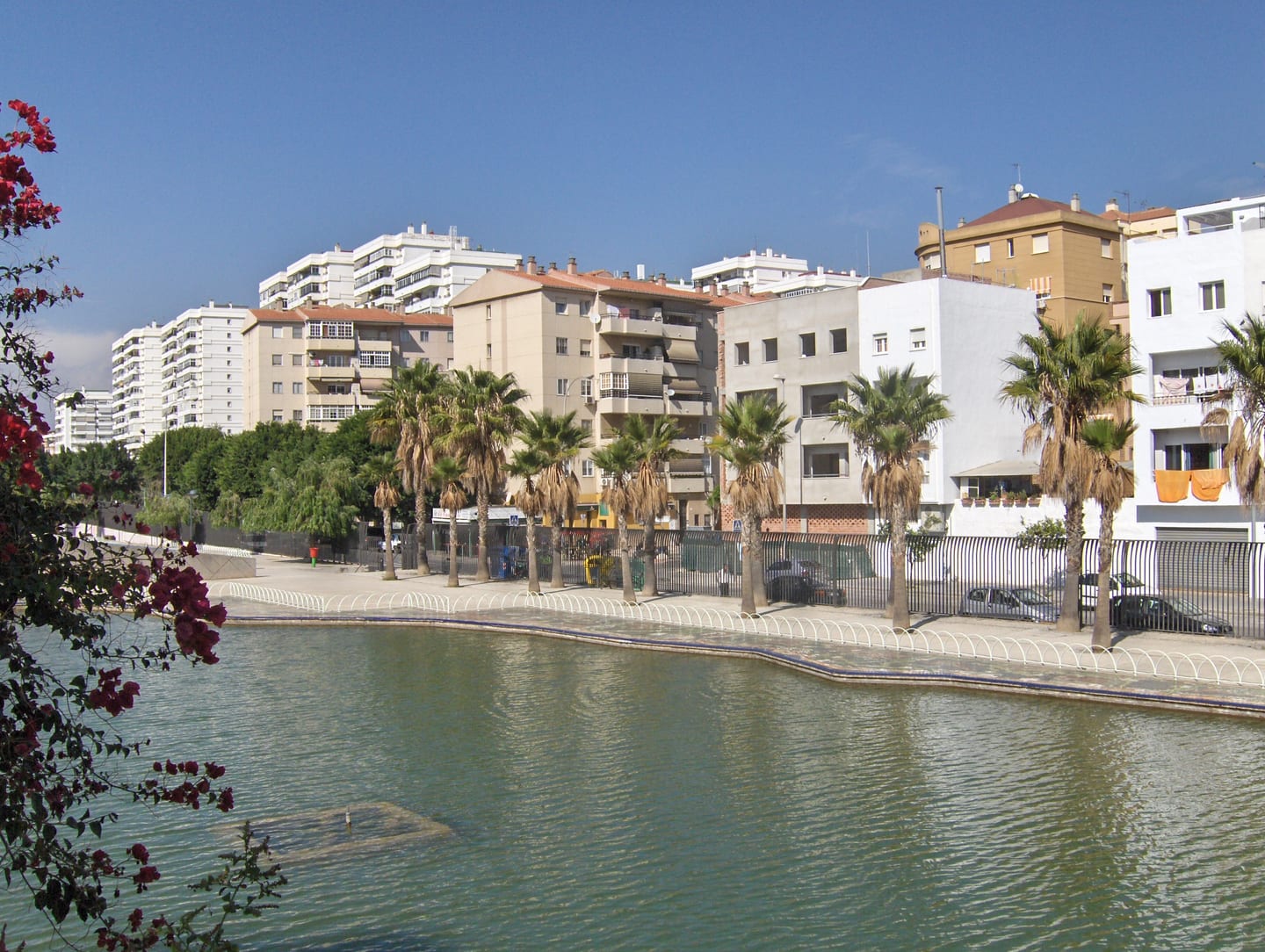 MILABEKA area photograph of Parque del Oeste pond with palm-lined promenade and Parque Mediterráneo residential neighbourhood, Málaga