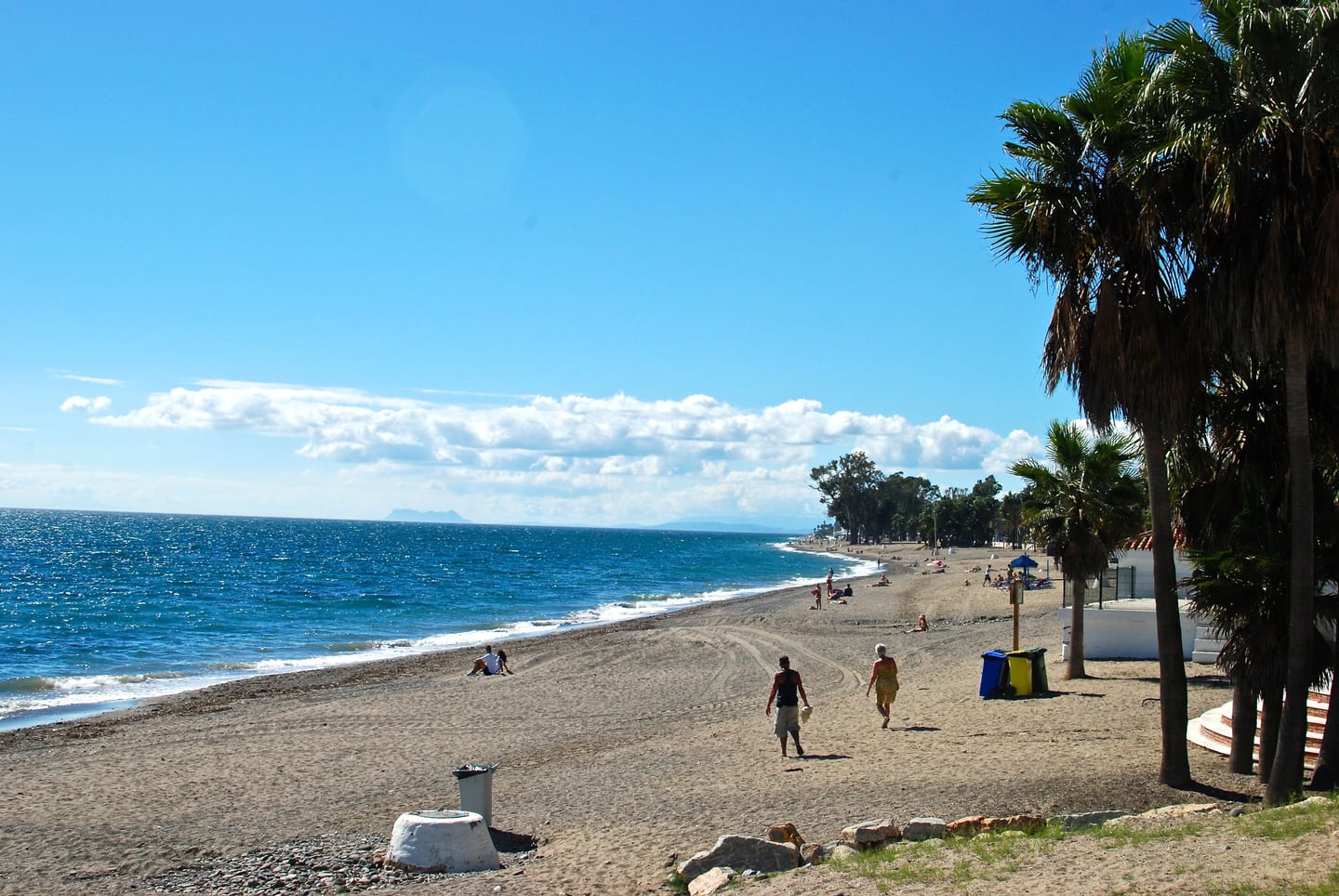 Playa de Cortijo Blanco beach and Mediterranean coastline with palm trees and Gibraltar in the background, shown as local context near BE SEVEN