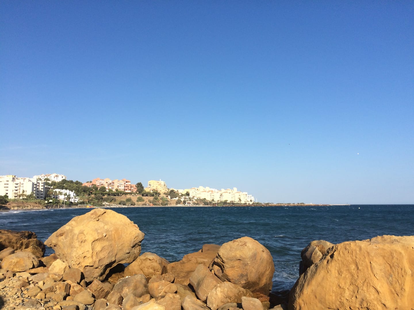 ALTOASIS area photograph of the rocky Mediterranean shoreline, Estepona townscape and blue sea on the Costa del Sol