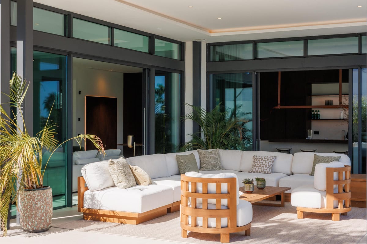 4OUR Villas: covered terrace with outdoor furniture in front of glass sliding doors.