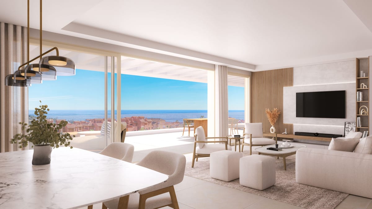 Rendered interior visualisation of ABSOLUTE ESTEPONA with a light dining table, white seating area, wooden TV wall panel and sliding glass doors overlooking the horizon.