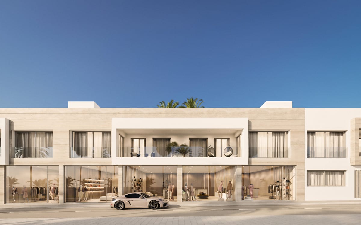 Project visualisation of ALCANTARA DEL MAR APARTMENTS with a symmetrical street façade: wide glazed frontages on the ground floor with fitted retail spaces featuring clothes rails and figures visible inside, a covered loggia on the first floor with lounge chairs and a hanging chair, and a sports car outside the entrance.