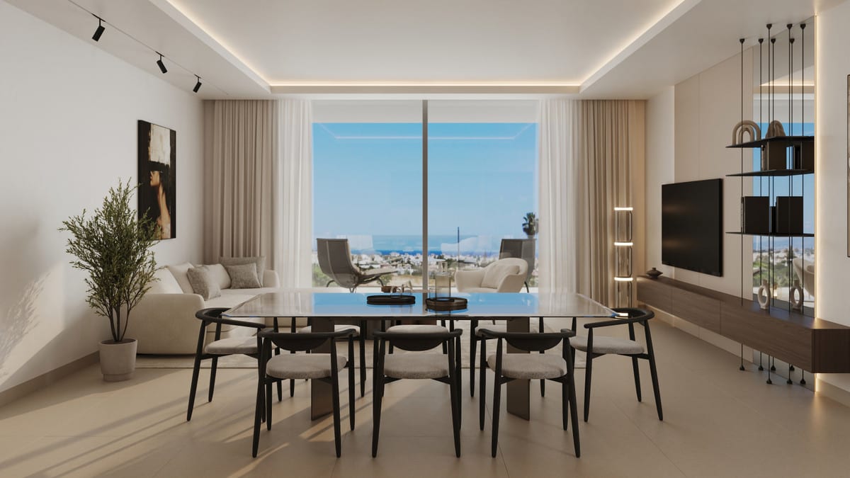 Project visualisation of ALCANTARA DEL MAR APARTMENTS showing a dark dining table with eight chairs in the foreground, a cream sofa in the background, wall shelving with a television, indirect ceiling lighting and a large sliding glass door overlooking buildings and blue sky.