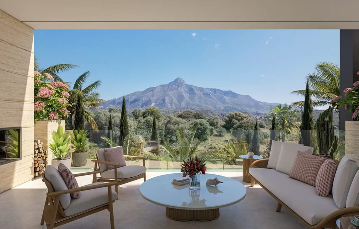 Rendered covered terrace with light lounge furniture, a glass balustrade and mountain views.