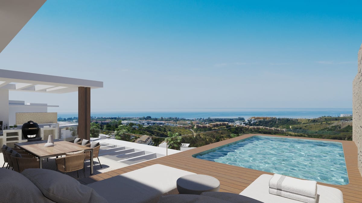 Development visualisation of ALTEZZA SUITES with a terrace, timber decking, small rectangular pool, dining table with chairs, barbecue grill and glass balustrade overlooking buildings and a body of water on the horizon.