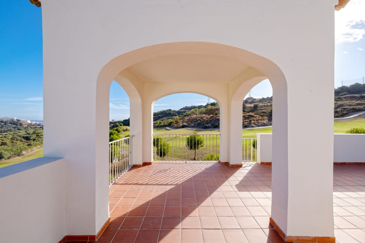 ALTOASIS: covered terrace with white arches and terracotta-coloured floor tiles
