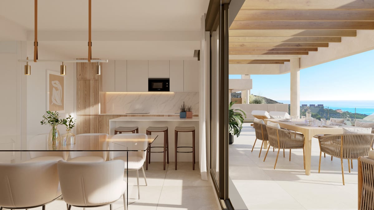 Project visualisation of ATRIA - PHASE 2 with an open-plan kitchen, dining table and a covered terrace with wooden beams overlooking green hills and the sea.