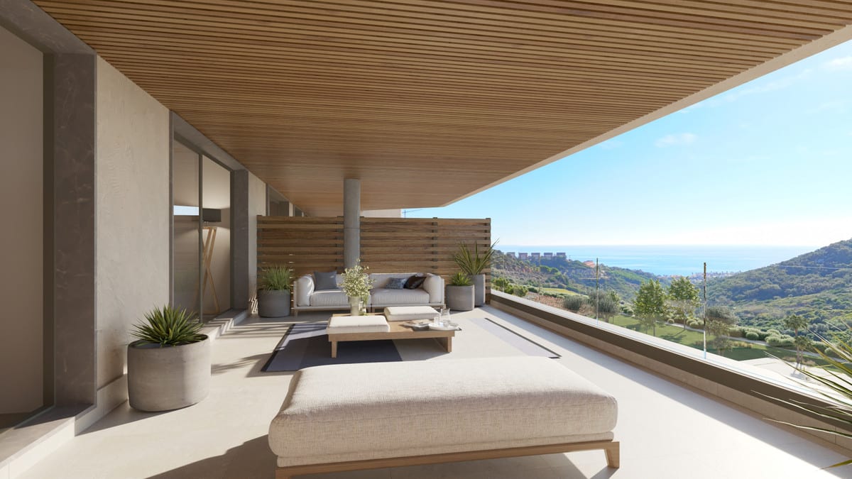 Project visualisation of ATRIA - PHASE 2 with a spacious terrace, sun lounger, seating area, wooden ceiling and glass balustrade overlooking hills and the sea.