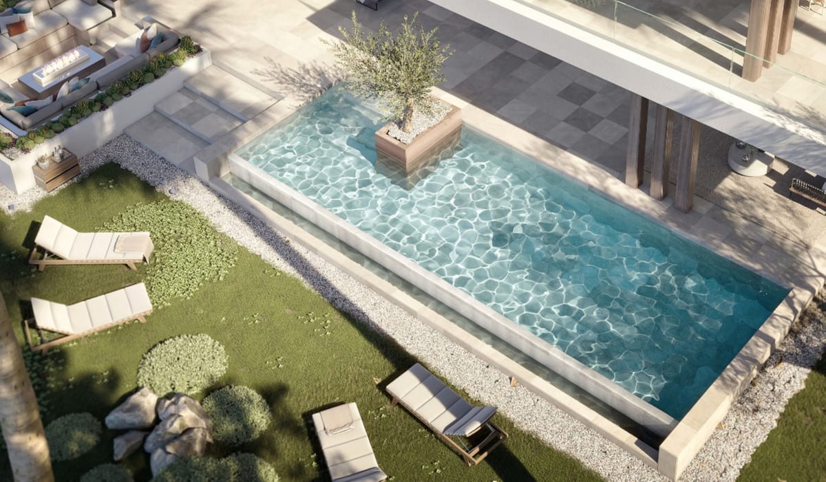Overhead view of the rectangular pool with a planted island, sun loungers on the lawn and gravel borders.