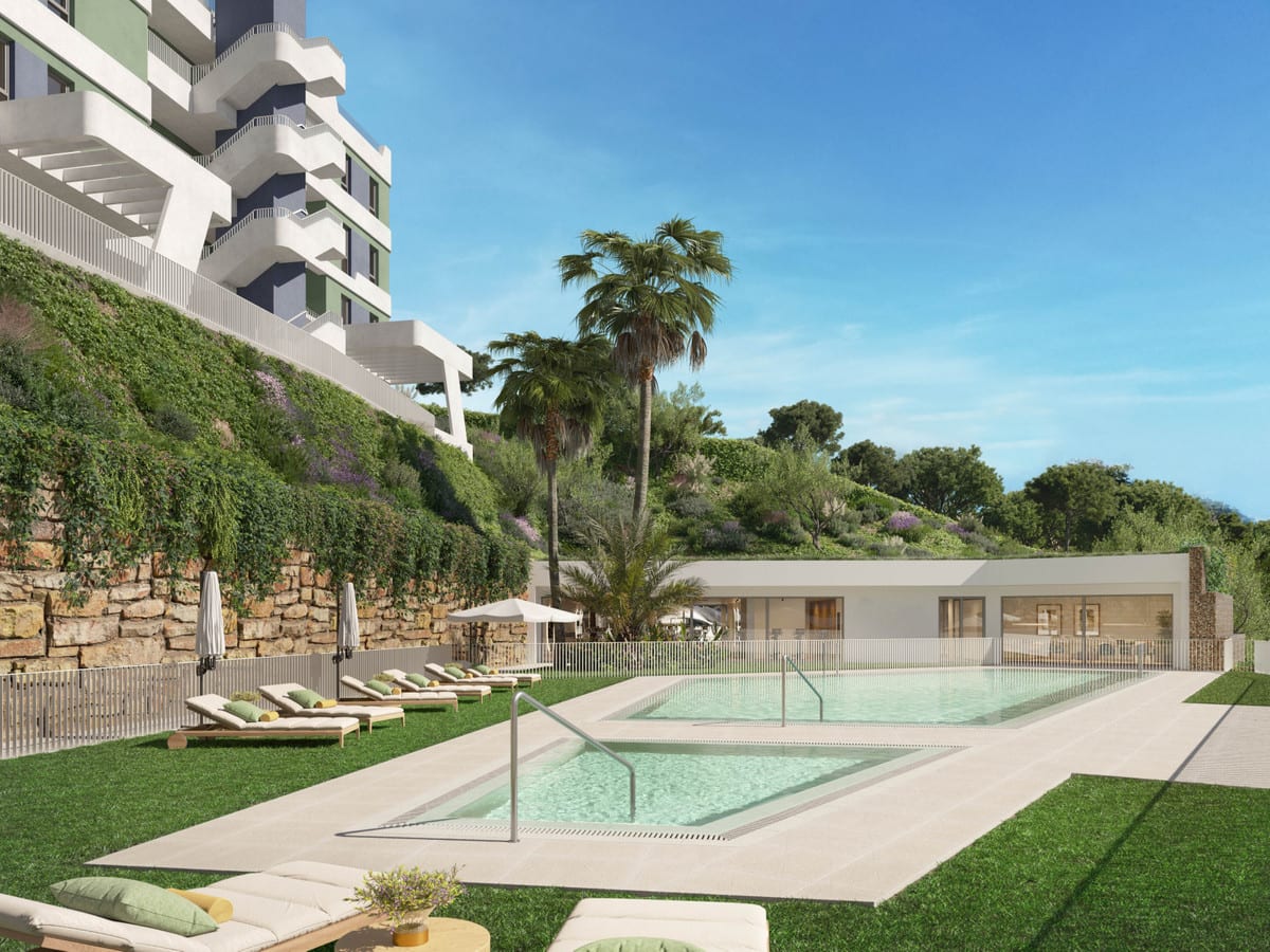 Rendered project visualisation of BAHIA with two swimming pools, sun loungers on the lawn, parasols, a palm tree and a low pavilion building against a landscaped terraced slope.