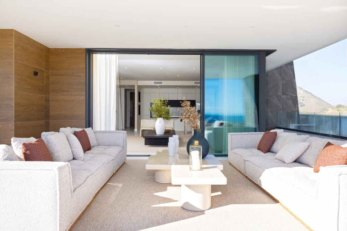 Covered terrace seating connected to the interior through open sliding glass doors.