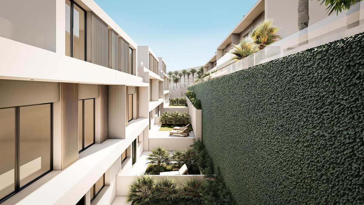 Rendered internal walkway at BRISAS DEL MAR with beige façades, wood-effect slats, glazed sliding doors, sun loungers, palm trees and a tall planted wall on the right-hand side.