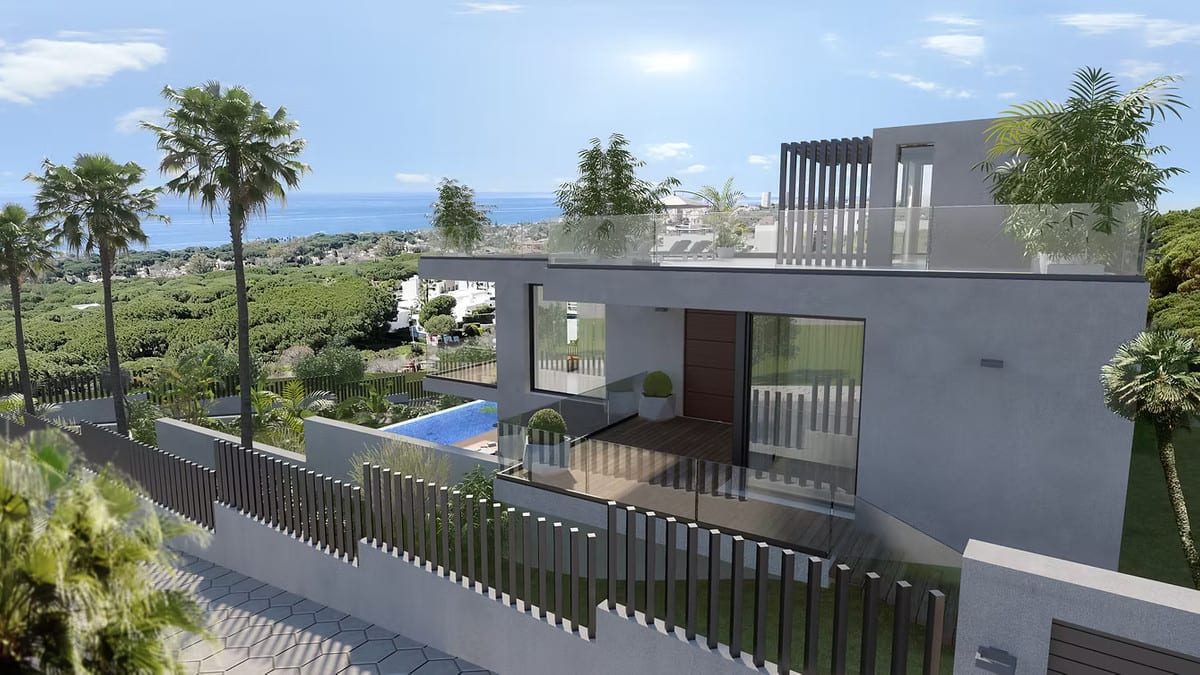 Side view of CABOPINO GARDENS - VILLA 12 with a glass-railed terrace and the sea in the background.