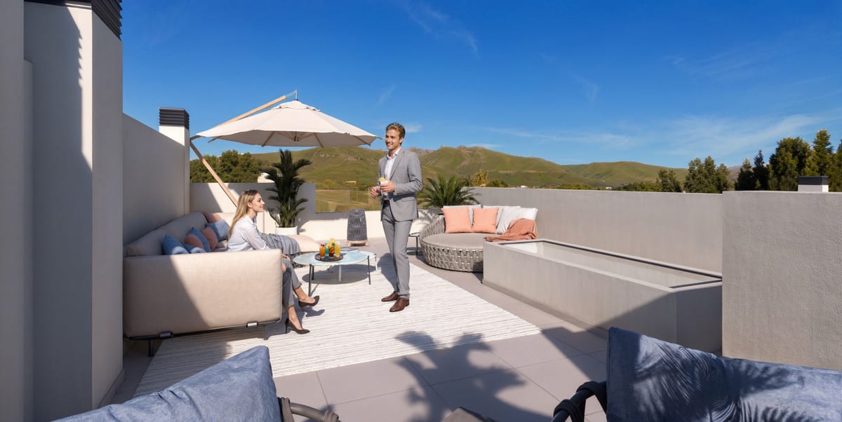 Project visualisation of CALAGOLF BY MARINSA with a furnished roof terrace, lounge seating area, parasol, round seating element and a green mountain landscape in the background.