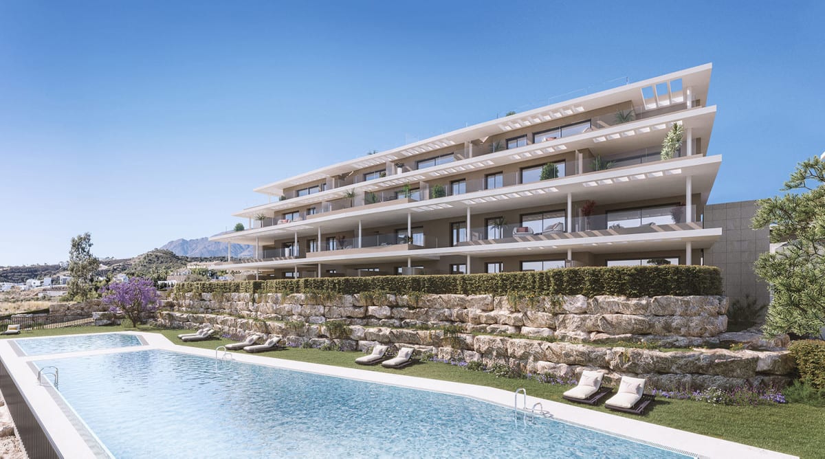 Project visualisation of CAPRI - FASE 2 featuring a modern building with wide cantilevered balconies, a natural stone retaining wall, green hedges and an outdoor swimming pool with sun loungers on the lawn.