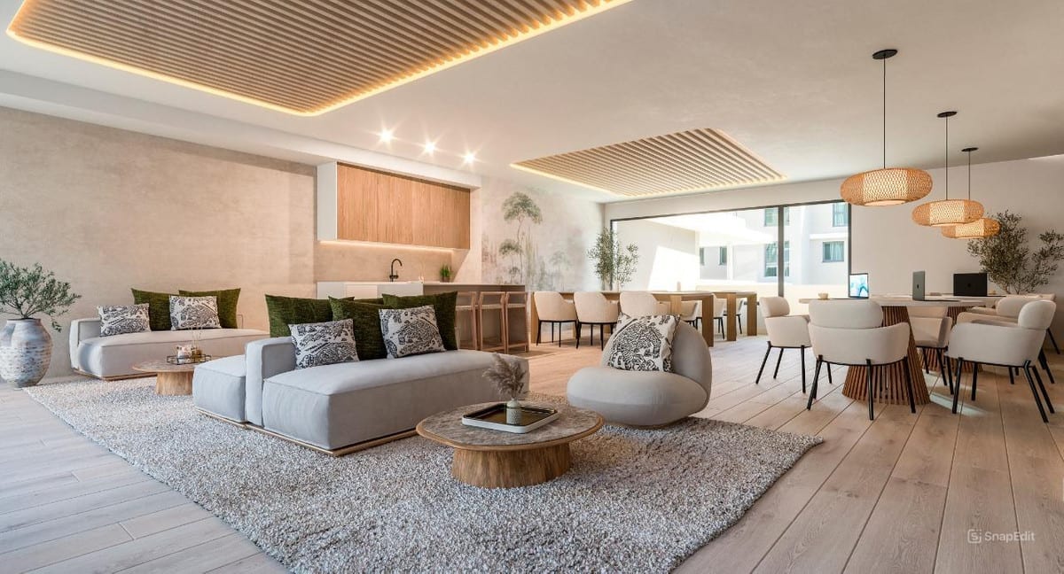 Visualisation of the shared coworking space at CAPRI - FASE 3 with seating, an open kitchen, a round table and pendant lights.