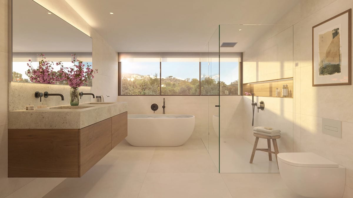 Bathroom visualisation of CASATALAYA RESIDENCES with a wooden vanity unit, stone double washbasin countertop, two wall-mounted taps, freestanding bath, glass shower screen, toilet and a horizontal window overlooking greenery.