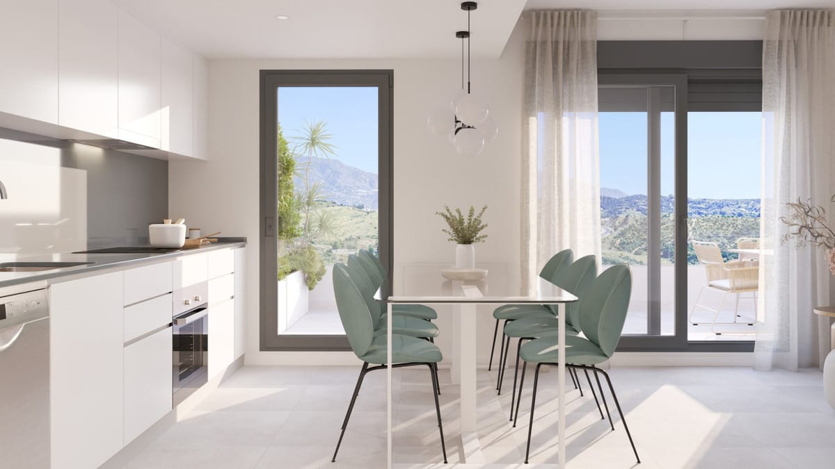 Project visualisation of the kitchen and dining area at CULMIA CALA SWING MIJAS FASE II with white cabinets, a dark worktop, built-in oven, four turquoise chairs at a white dining table and a sliding door with hill views.