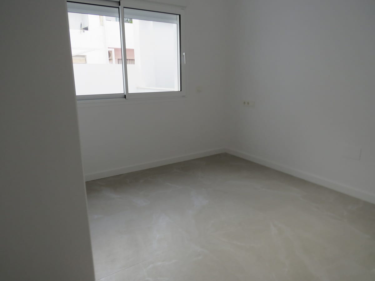 Empty room at EDIFICIO VENECIA with white walls, light grey tiled flooring and a wide window.