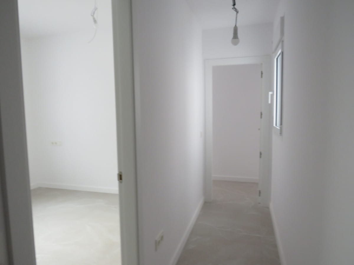 Hallway at EDIFICIO VENECIA with white doors, a window and light grey tiled flooring.
