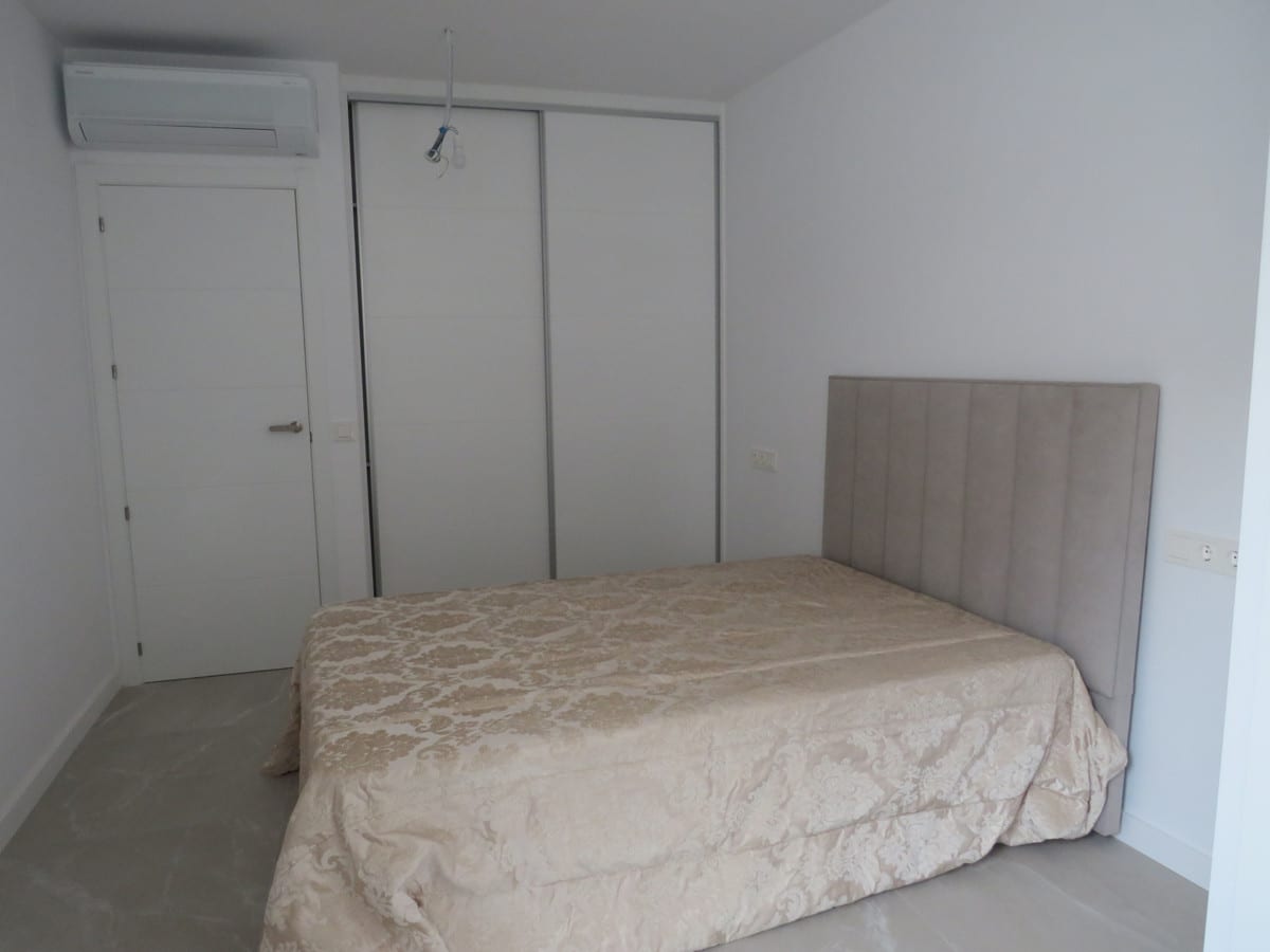 Bedroom at EDIFICIO VENECIA with a bed, upholstered headboard, fitted wardrobe and wall-mounted air conditioning unit.