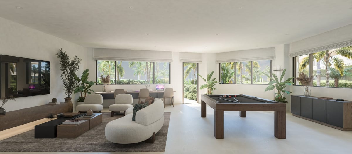 Rendered interior visualisation of IDYLLIC with a seating area featuring a curved sofa and armchairs, television, pool table, worktable with chairs, and large windows overlooking palm trees and planting.