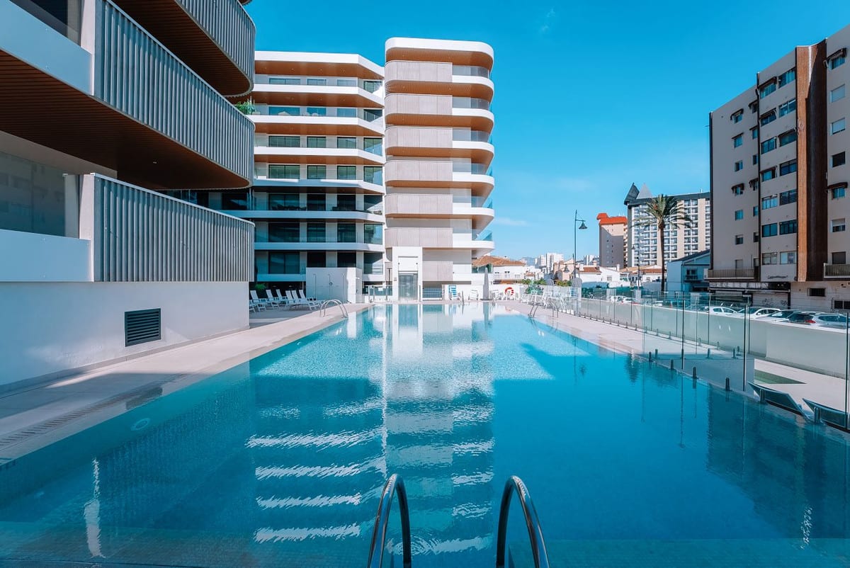 JADE TOWER WITH FURNITURE with an outdoor swimming pool, glass enclosure, sun loungers and surrounding buildings.