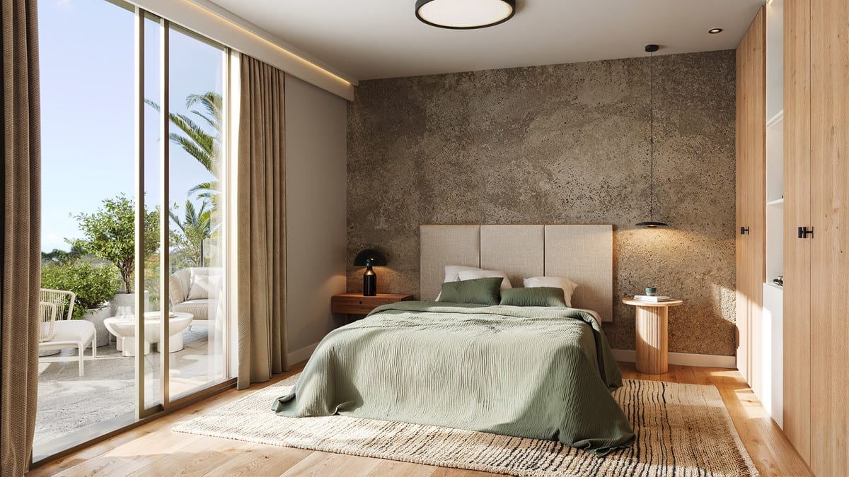 Project visualisation of LAKÜN featuring a bedroom with green bed linen on an upholstered bed, wooden flooring, an accent wall with a stone-like texture and sliding glass doors to a terrace with an outdoor seating area.