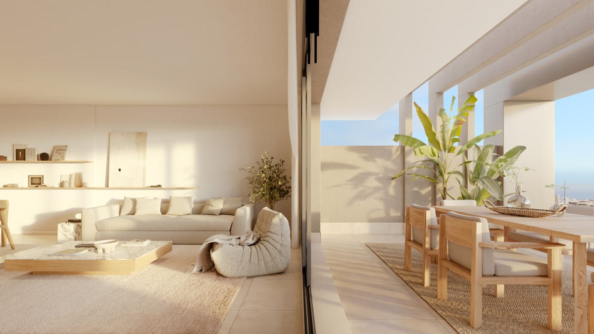 Project visualisation of LAS MESAS INFINITY HOMES featuring a bright living room beside a covered terrace with a wooden dining table and plants, connected by large sliding glass doors.