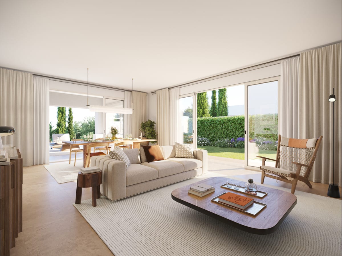 Project visualisation of LAS VILLAS–SOTOGRANDE featuring a seating area, light-coloured sofa, wooden coffee table, dining table in the background and glass sliding doors opening onto a green garden.