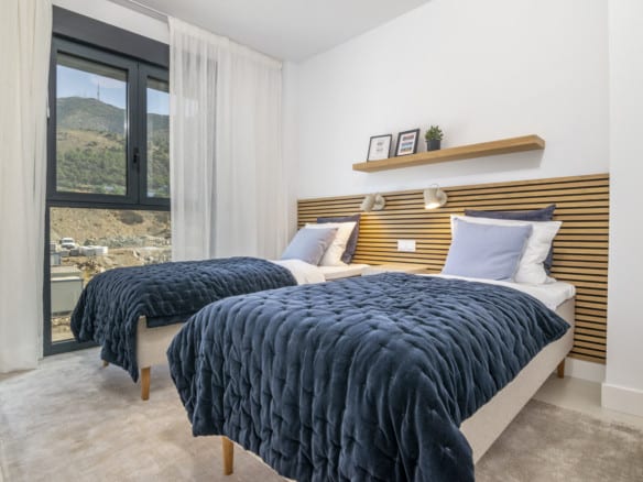 LOMAS 2: bedroom with two single beds, dark blue bedspreads, wooden slatted feature wall and window with mountain views.
