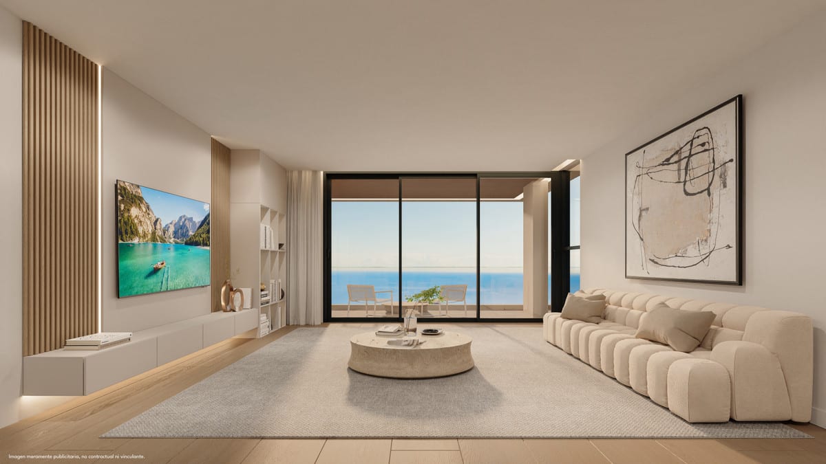 Project visualisation of the living room at LOMAS UNIQUE A, with a cream sofa, round stone coffee table, wooden wall slats, wall-mounted television above a floating unit and wide sliding glass doors with sea views.