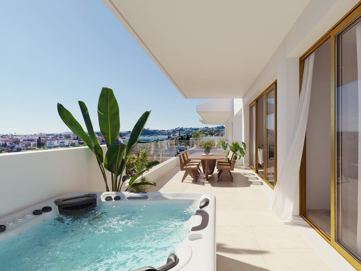 Project visualisation of LUMINAL HOMES featuring a terrace with a hot tub in the foreground, a wooden dining table with chairs, large-leaved plants and a glass balustrade.