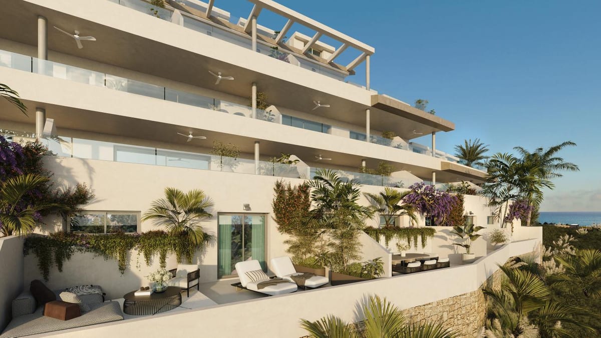 Project visualisation of MACAN BEACH RESIDENCES with spacious terraces, glass balustrades, ceiling fans, sun loungers and planting, with the sea visible in the background.