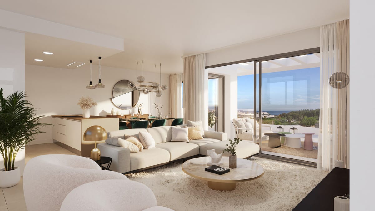 Project visualisation of MALA KAI featuring a bright open-plan living room, an off-white corner sofa, round marble coffee table, kitchen island with a wooden worktop, dining area with green chairs and sliding glass doors opening onto a terrace with sea views.