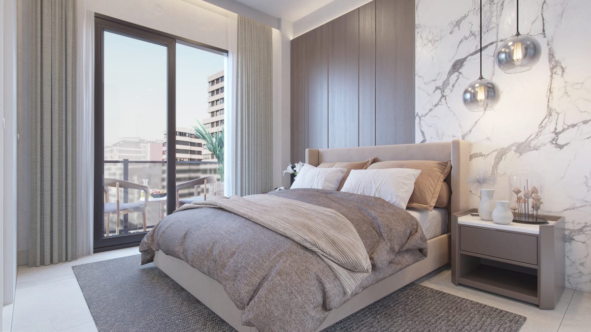 Project visualisation of MALAGA CENTRUM featuring a bedroom with an upholstered bed, dark wood-effect wall panels, a white marble-effect feature wall, hanging glass lights and sliding doors to a balcony.