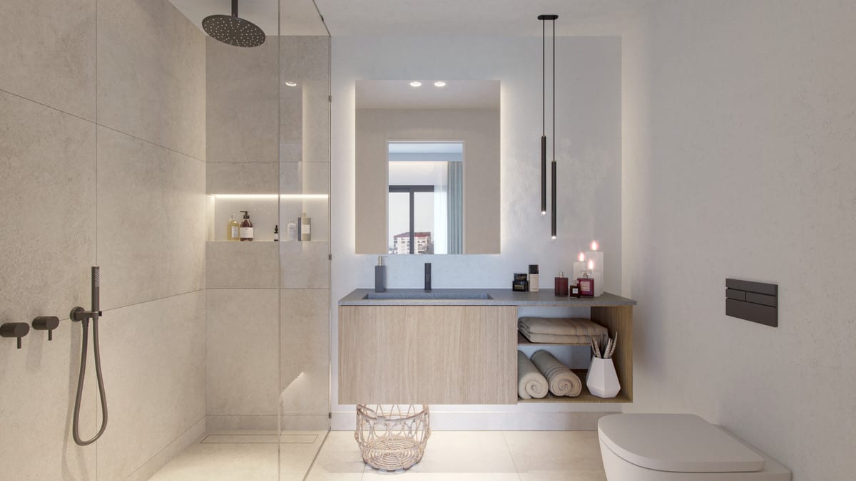 Project visualisation of MALAGA CENTRUM featuring a bathroom with a walk-in shower behind a glass screen, large sand-beige tiles, a floating wooden vanity unit with a grey basin, illuminated mirror, pendant lights and toilet.