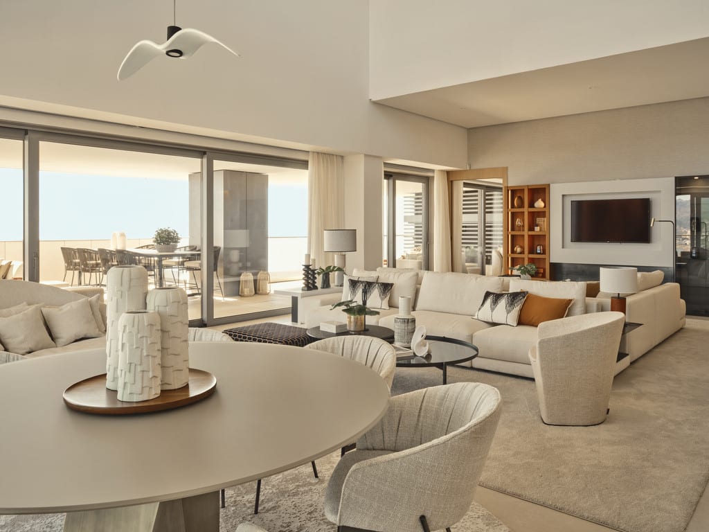 Photograph — MALAGA TOWERS: Furnished living room with a round dining table, sofas, a television and sliding doors to the terrace.