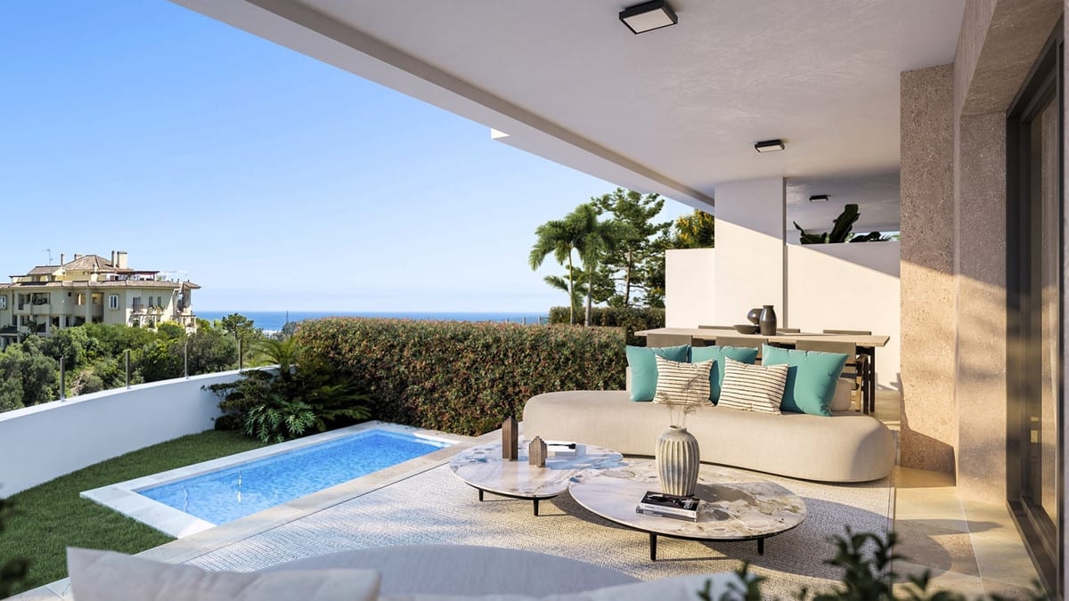 Rendered terrace visualisation of MARINE HILLS - STAGE 1 with a covered lounge area, two round coffee tables, a small pool, green hedge and sea views.