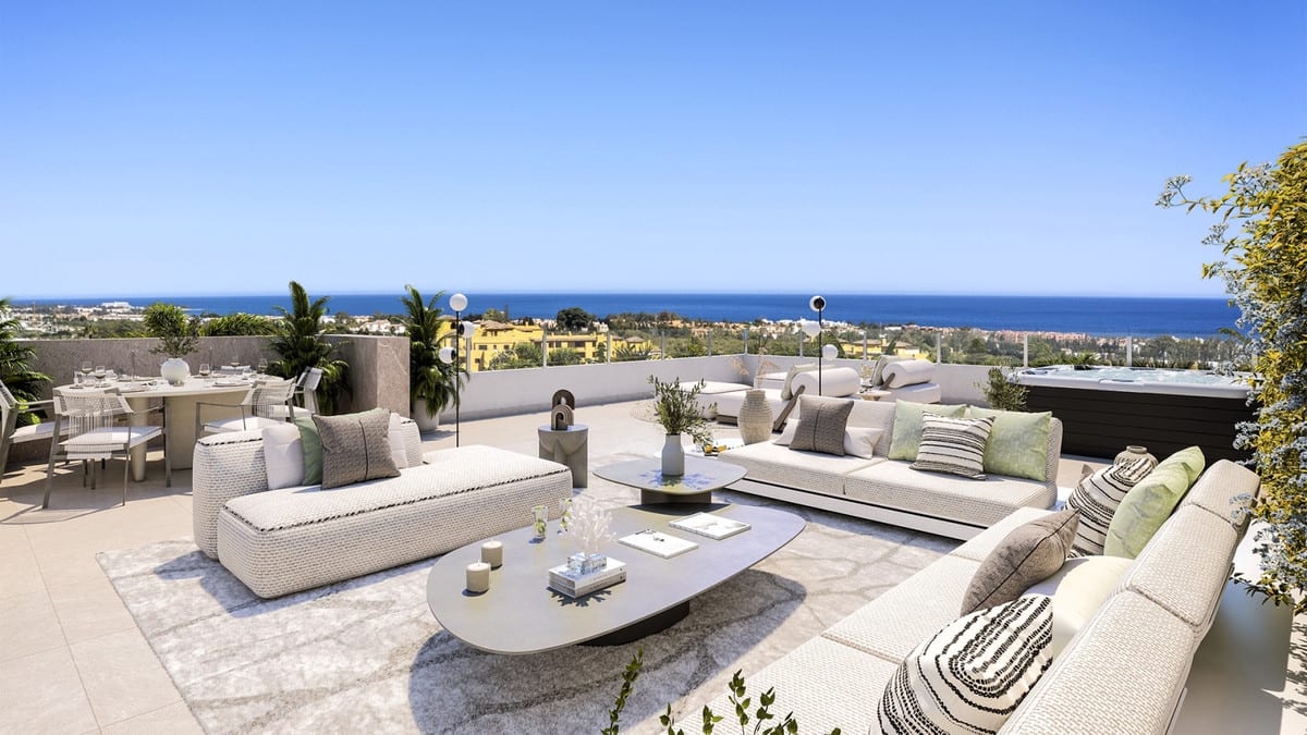 Project visualisation of MARINE HILLS - STAGE 2 with a spacious terrace, white lounge sofas, coffee table, dining area and an outdoor pool in the background with the sea on the horizon.