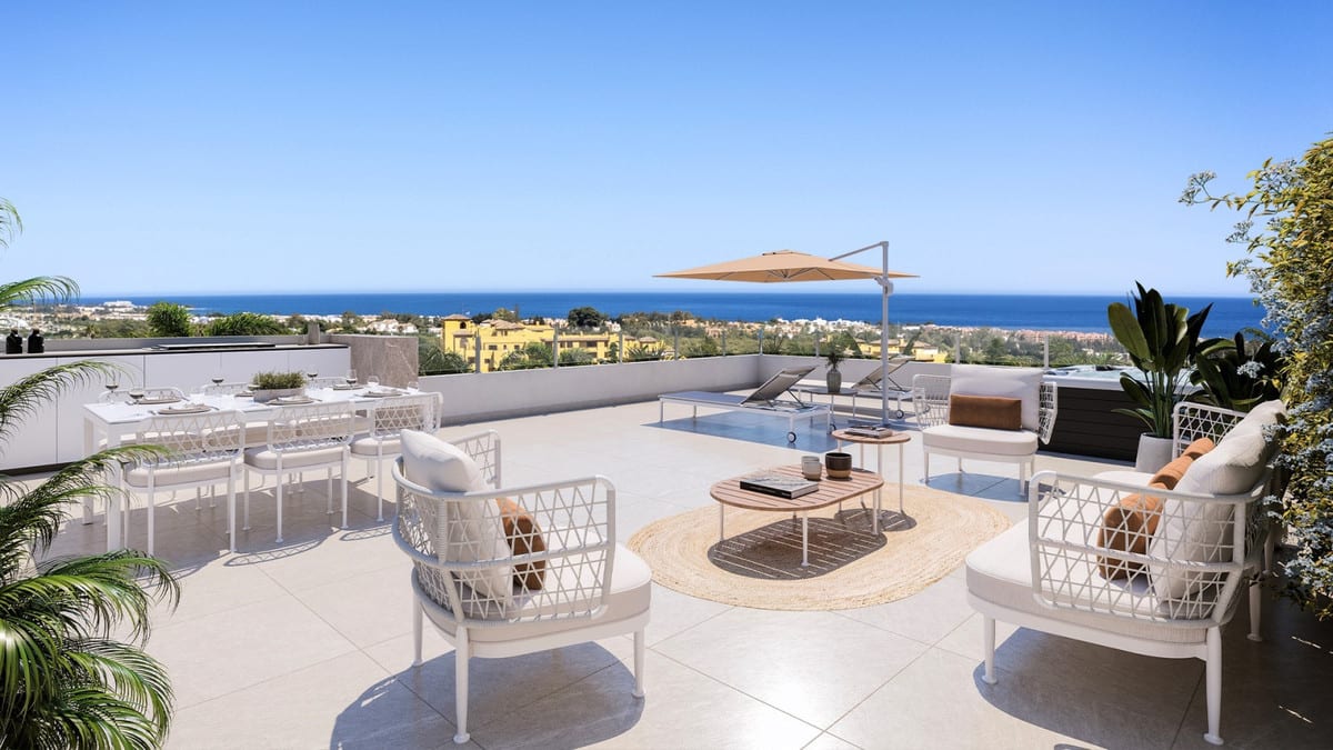 Project visualisation of MARINE HILLS - STAGE 2 with a terrace, dining table, two armchairs, sun loungers, parasol and outdoor pool in the background with the sea on the horizon.
