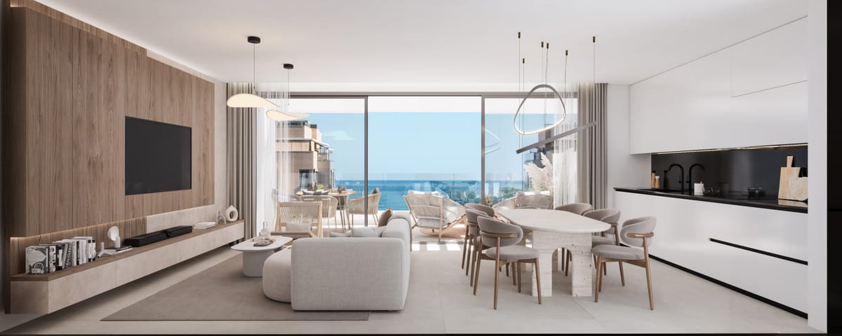Project visualisation of the living area at MILABEKA with a wooden TV wall, light-coloured seating area, oval dining table, hanging designer lights, white kitchen units with a dark worktop and wide sliding glass doors.