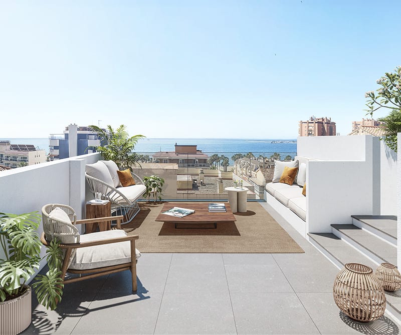 Project visualisation of MONTE SANCHA 28 with a furnished roof terrace, wooden armchair, white sofa, coffee table on a jute rug, glass balustrade and views of surrounding rooftops and the sea.