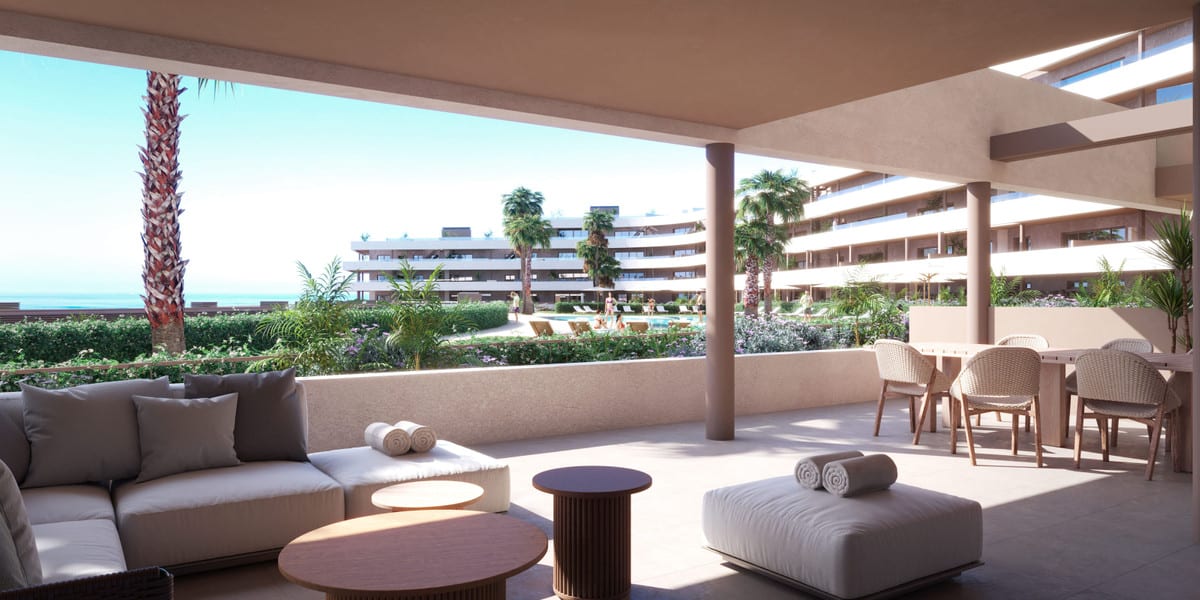 Project visualisation of the covered terrace at MORASOL - BUILDING 1 with a lounge sofa, dining table and views of the swimming pool and communal outdoor area.