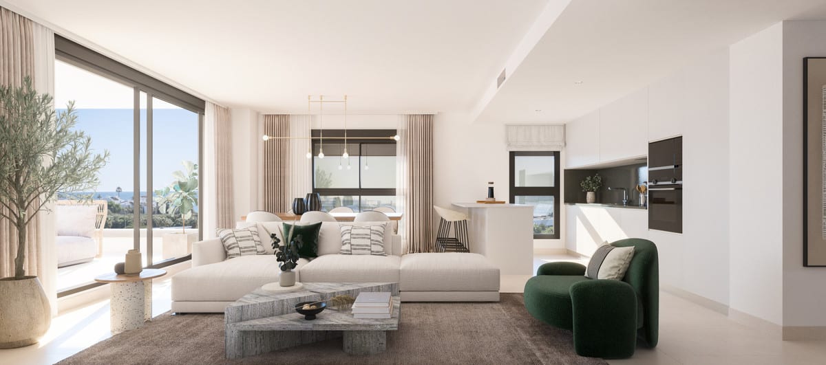 Development visualisation of NATURA ESTEPONA with a bright living room, cream L-shaped sofa, green round armchair, stone coffee table, dining area with pendant light and open white kitchen with breakfast bar.