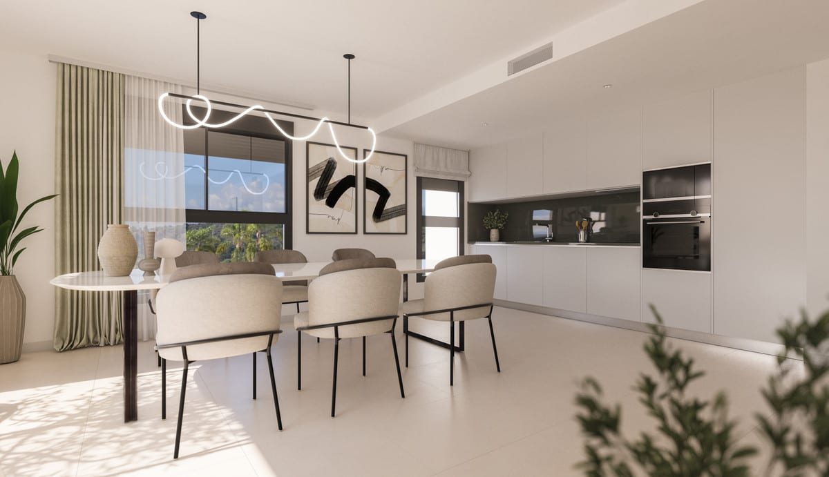 Development visualisation of NATURA ESTEPONA with an oval dining table, six beige upholstered chairs with black metal legs, sculptural neon LED pendant light and a white kitchen with a dark splashback and integrated appliances.