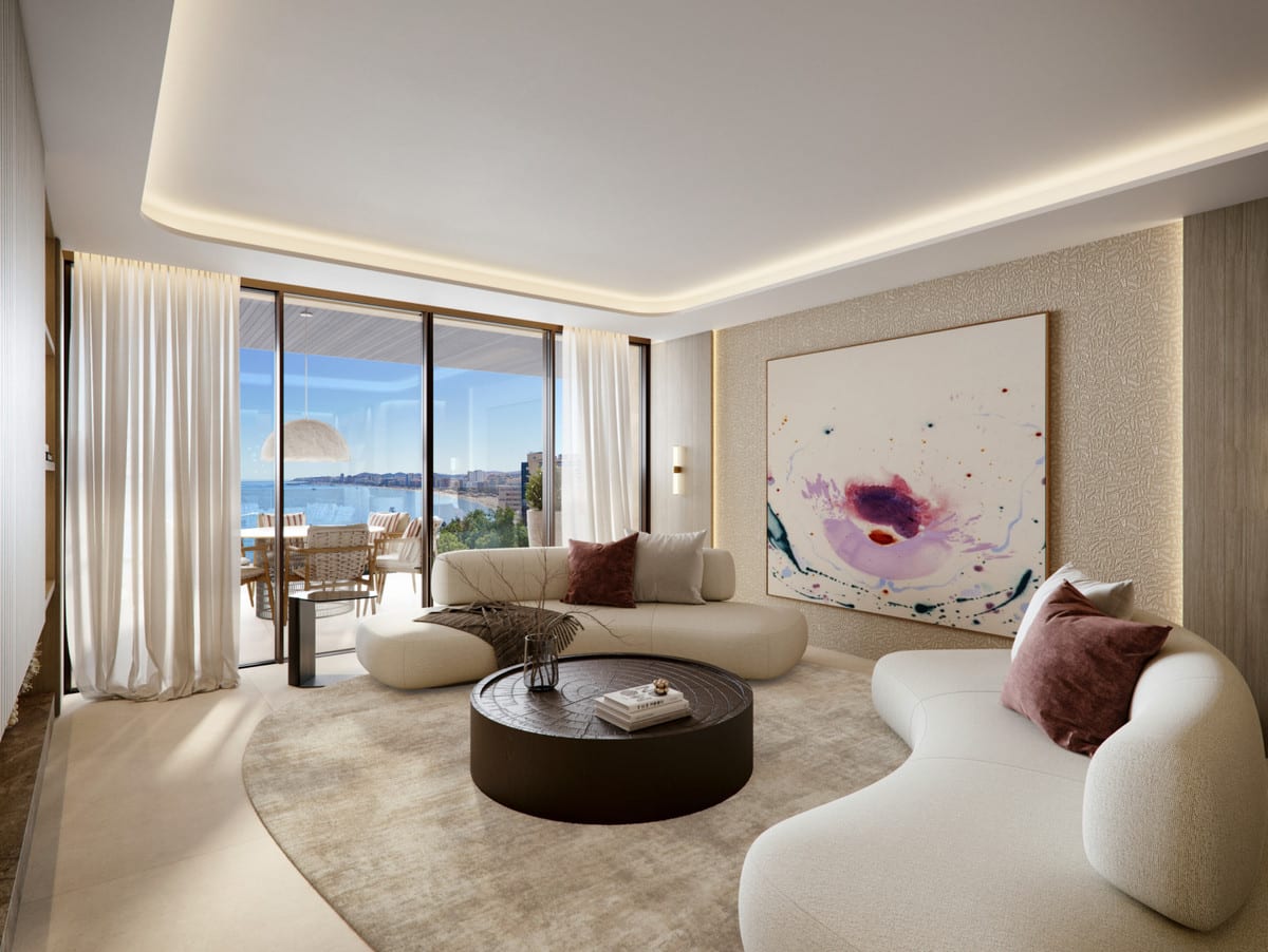 Rendered living room of ÓLEO with curved cream sofas, a round dark coffee table, a large abstract artwork and floor-to-ceiling sliding glass doors leading to a furnished terrace with sea views.